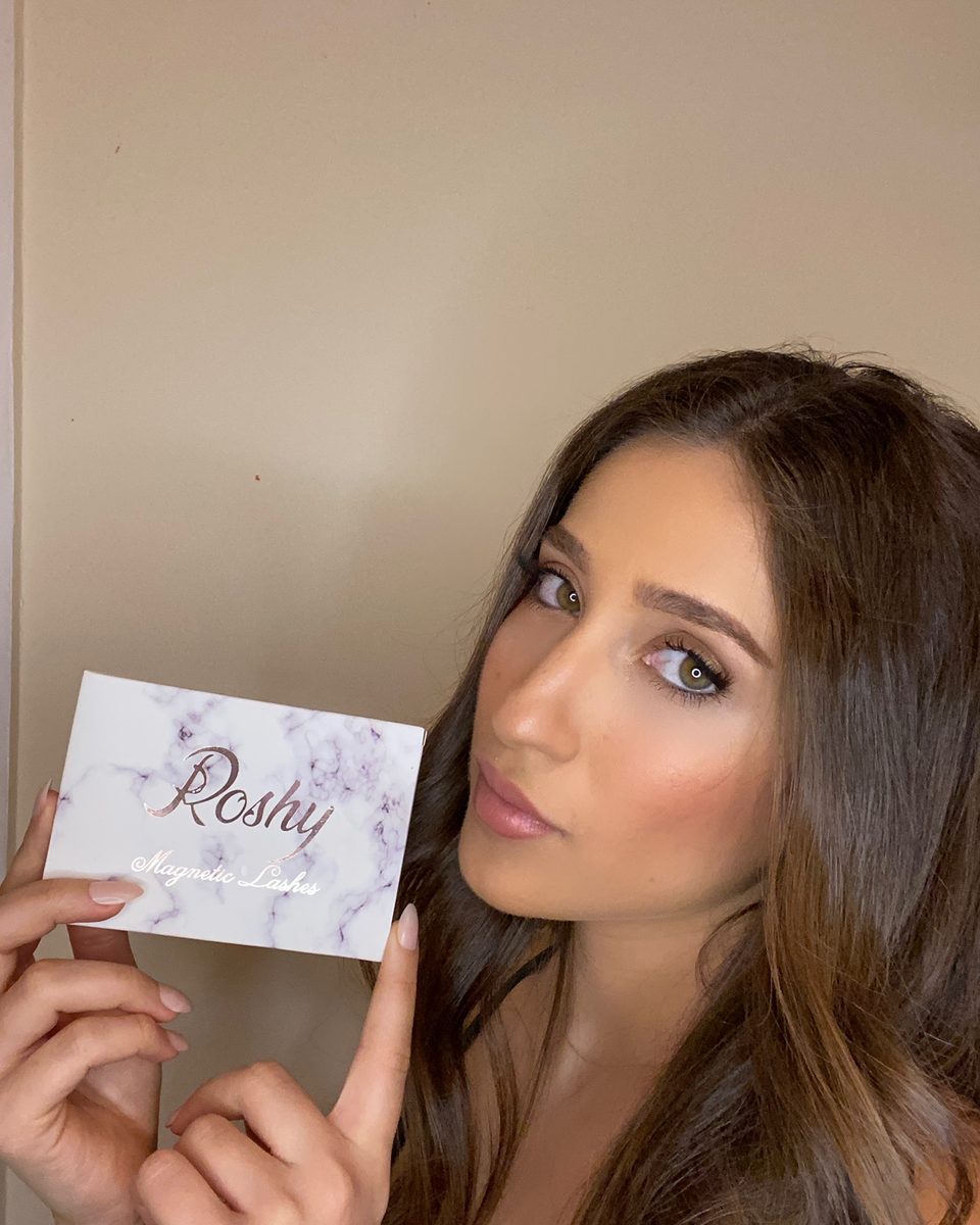 Wearing Roshy magnetic lashes, holding the Roshy box